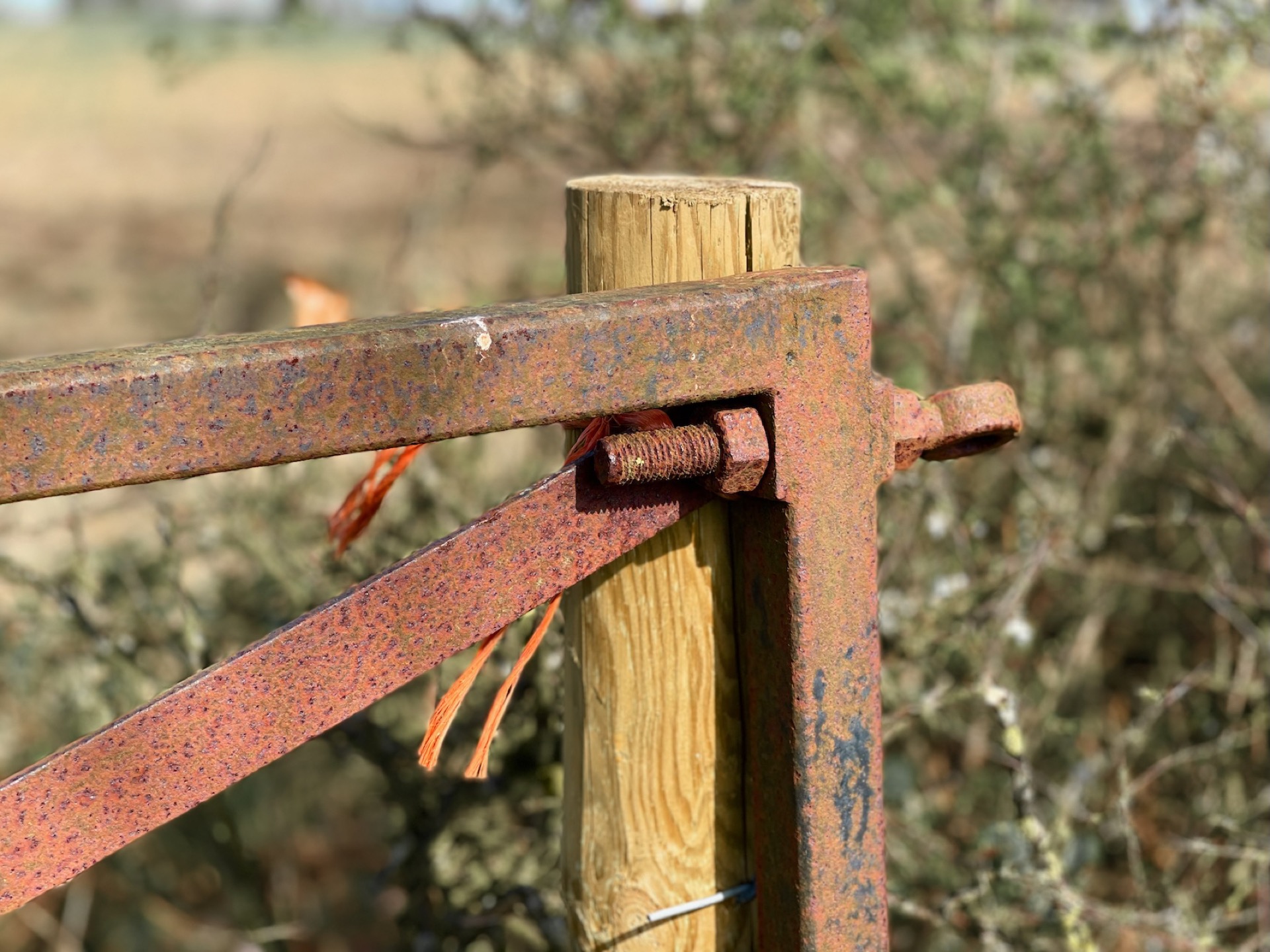 Gate leaning against post held with baler twine